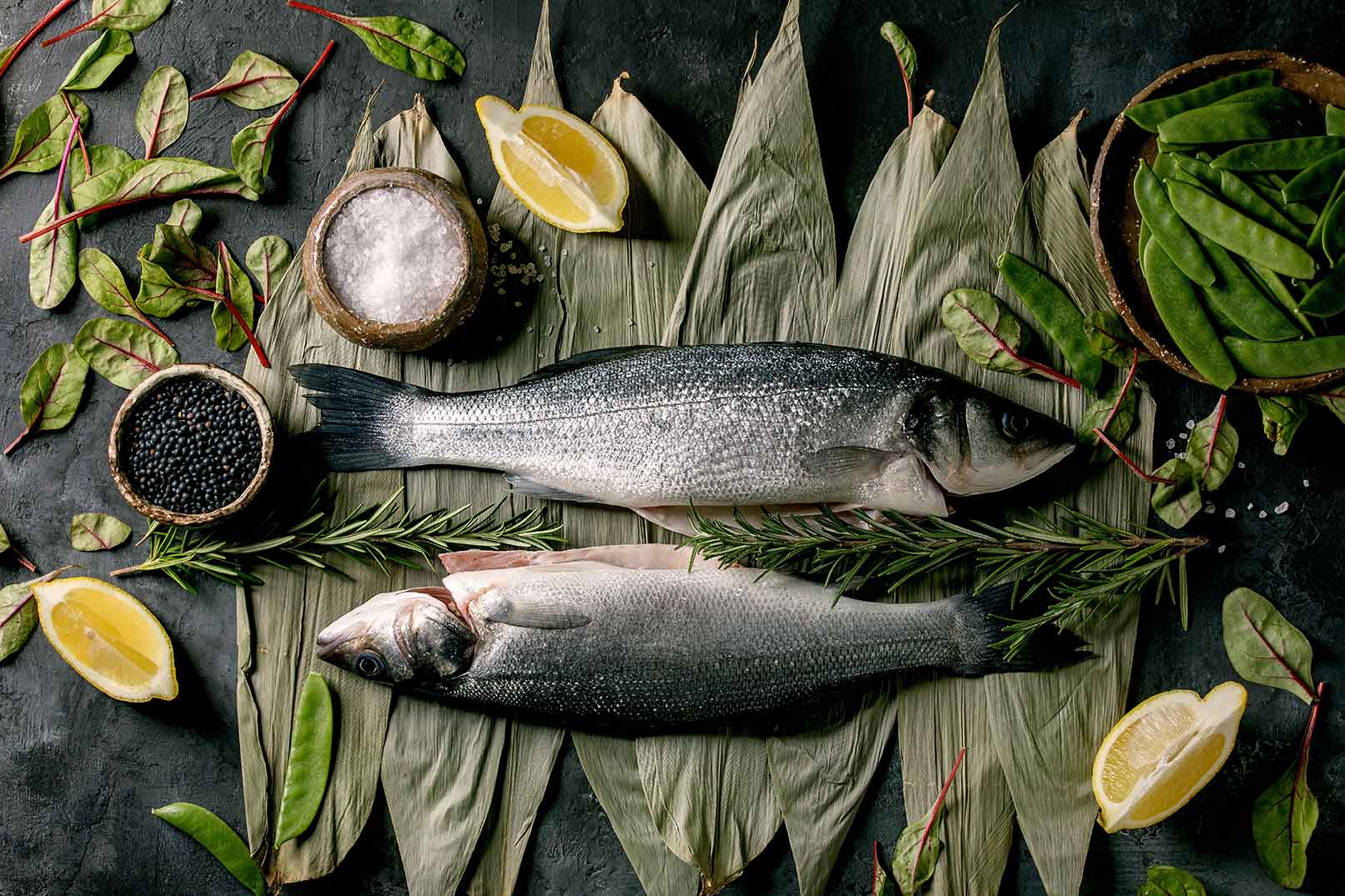 Fische auf grünen Blättern mit Salz und Pfeffern schön präsentiert
